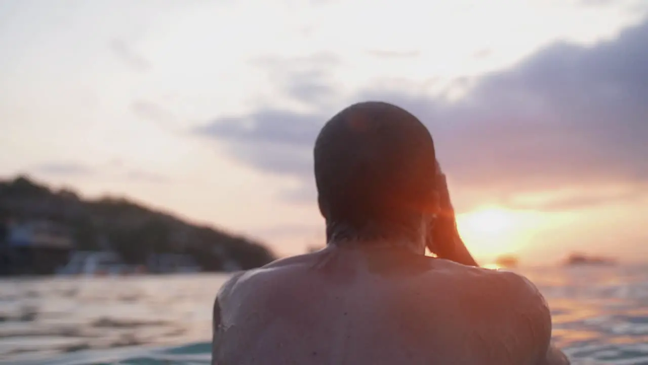 Swimmer emerging from the water from the sea during scenic sunset seascape travel destination background