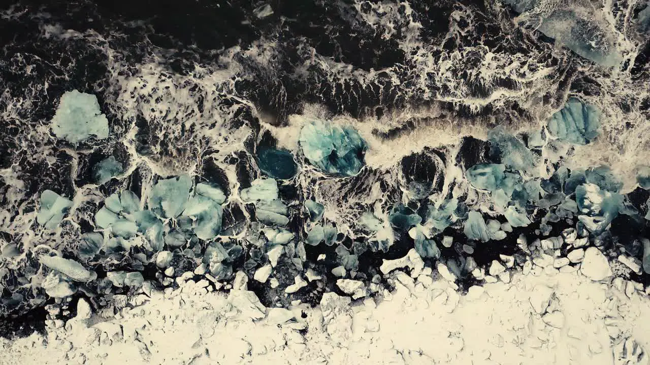 Cinematic drone moves show Black sand beach in Iceland filmed by drone in snowy conditions