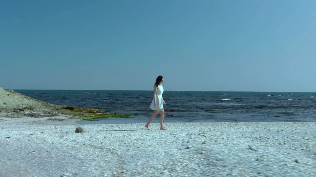 Pretty girl in white dress walk on the beach