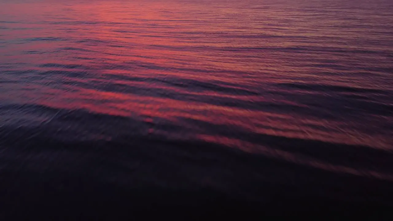 Water surface reflecting colorful sunset tilt up towards sky