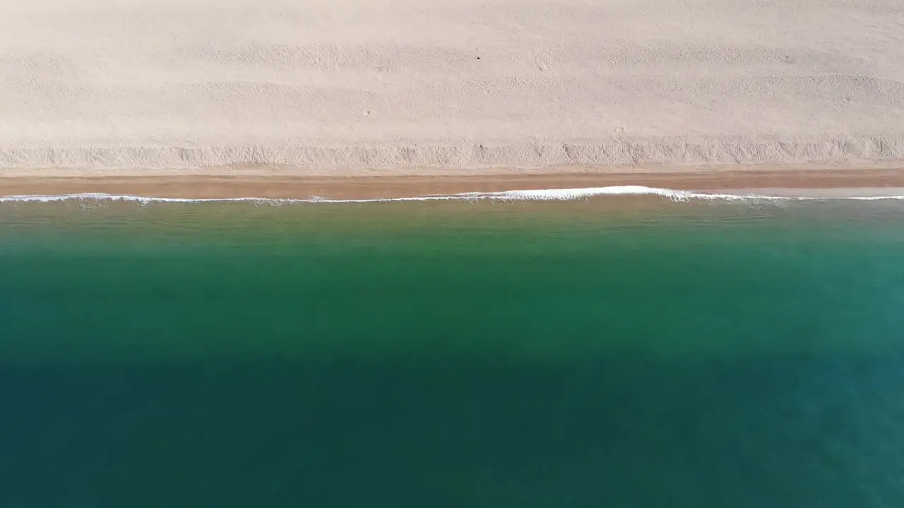 Aerial forward shot of Chesil Beach Dorset England showing beautiful colored sea against the shore