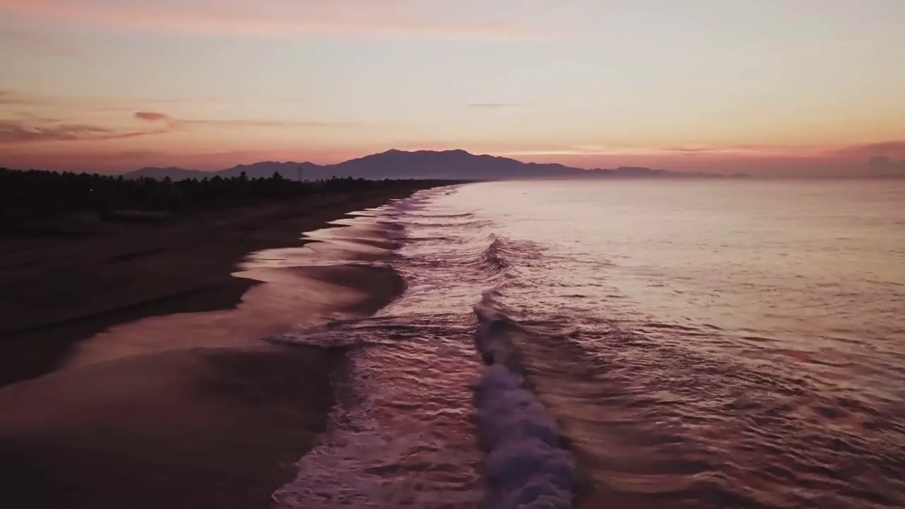 Aerial dolly out of beach seaside coast in Mexico in the evening low angle