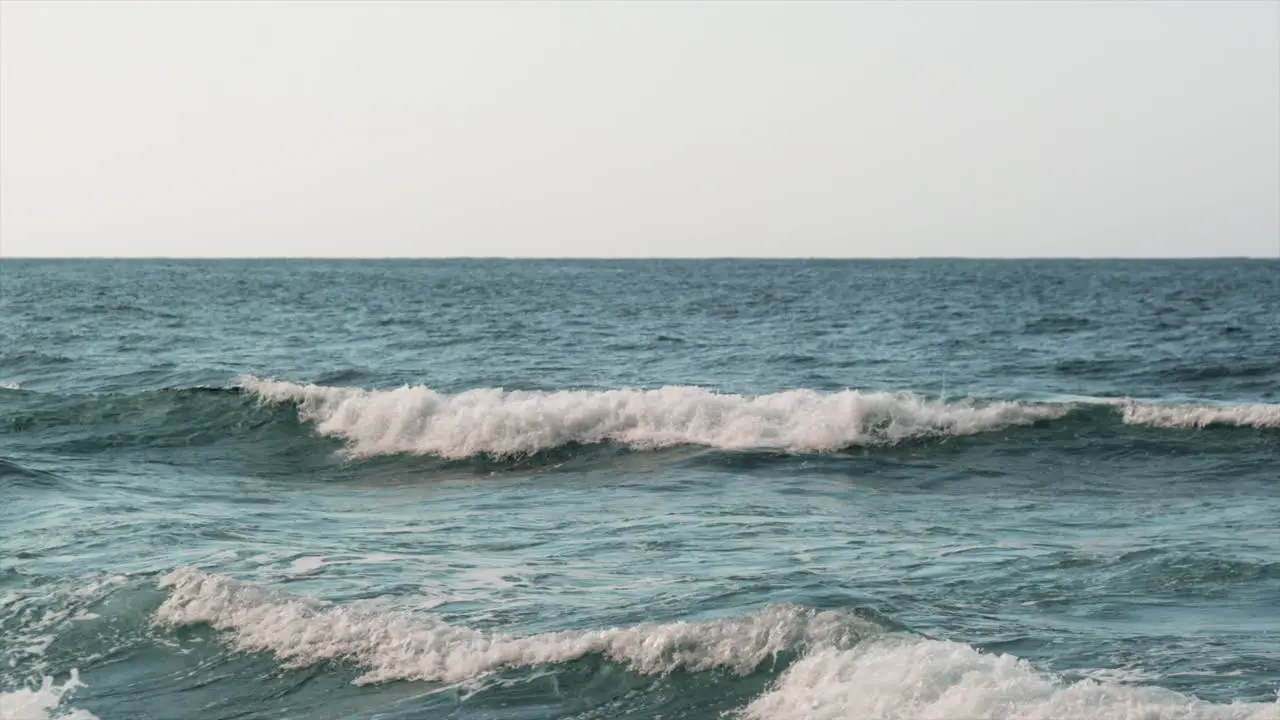 Slow motion static shot of vibrant blue waves of Pacific Ocean