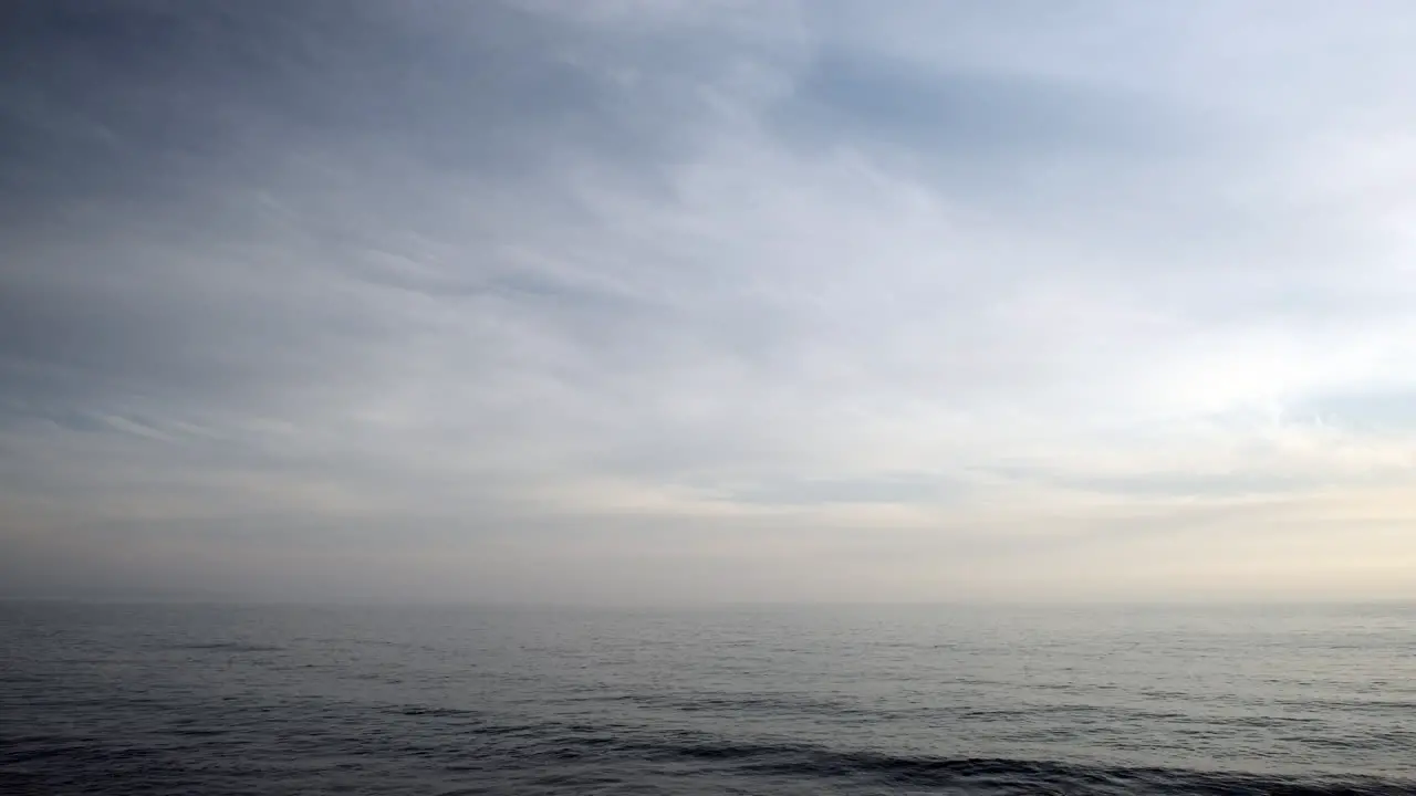 Calm serene blue water ocean waves of Malibu on a cloudy day in the evening