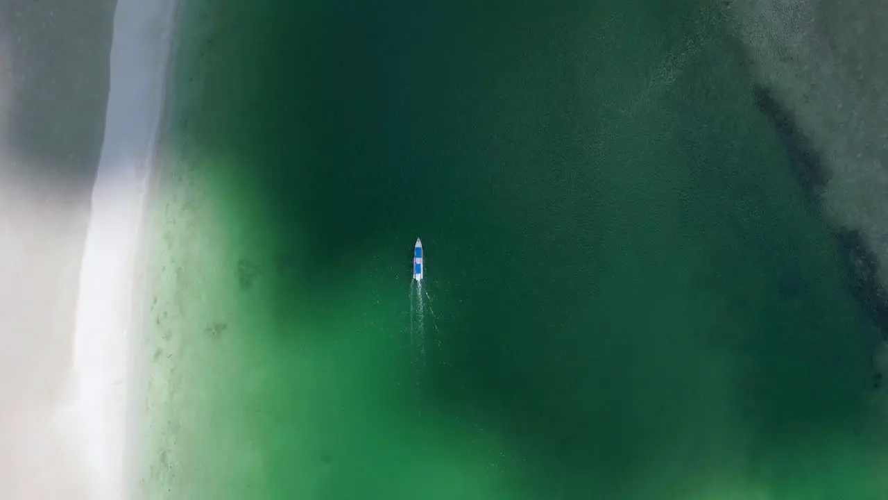 aerial top down of white boat motoring in