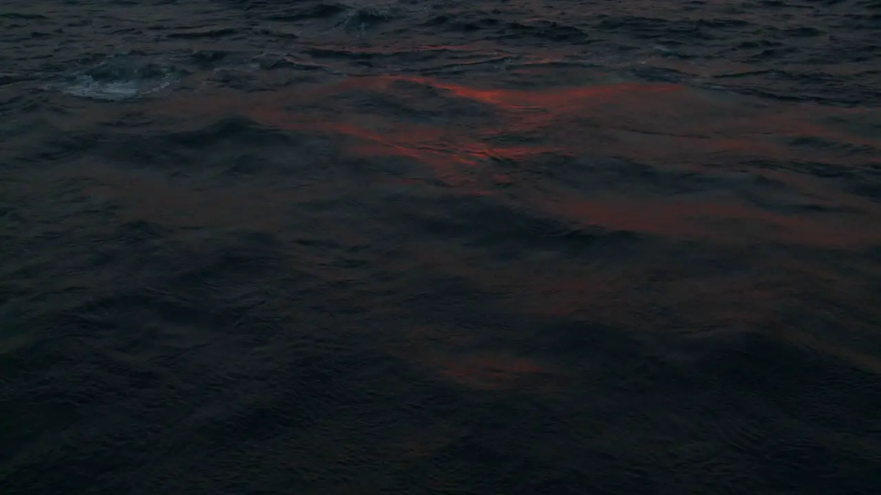 Red sunset light reflects off ocean waves