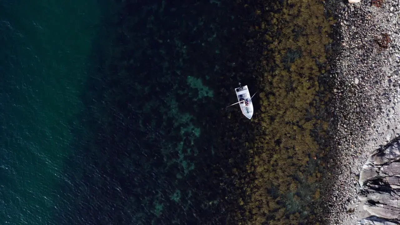 Person In Boat Paddles On Clear Blue Waters Off The Shore In Vikan Indre Fosen Norway