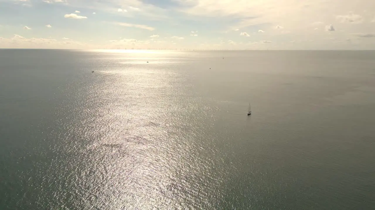 Aerial view Beautiful view sunset over sea surface beautiful wave with sailing boats in background Amazing light sunset or sunrise sky over sea beach with wave crashing in the ocean