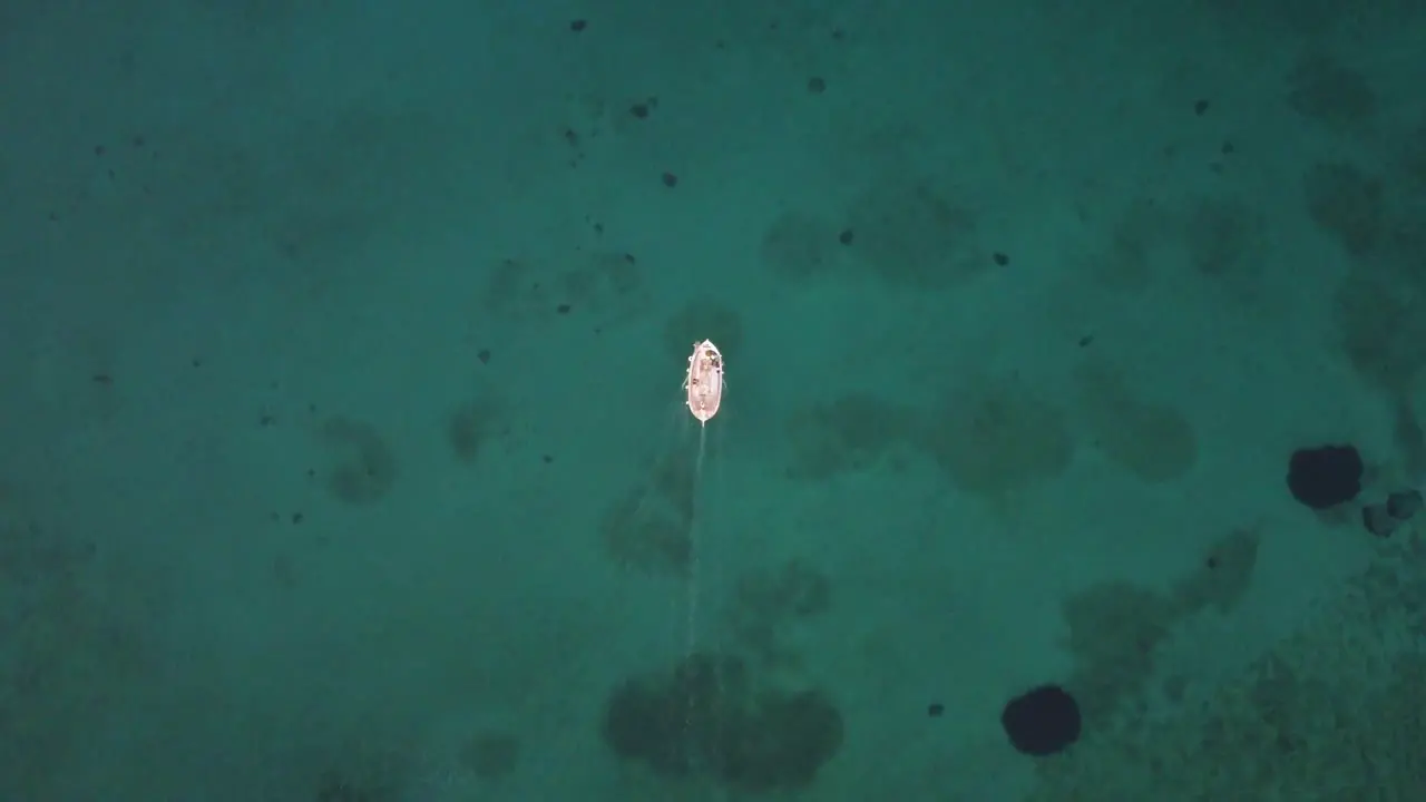 Birds eye view fishing boat over blue cinematic water