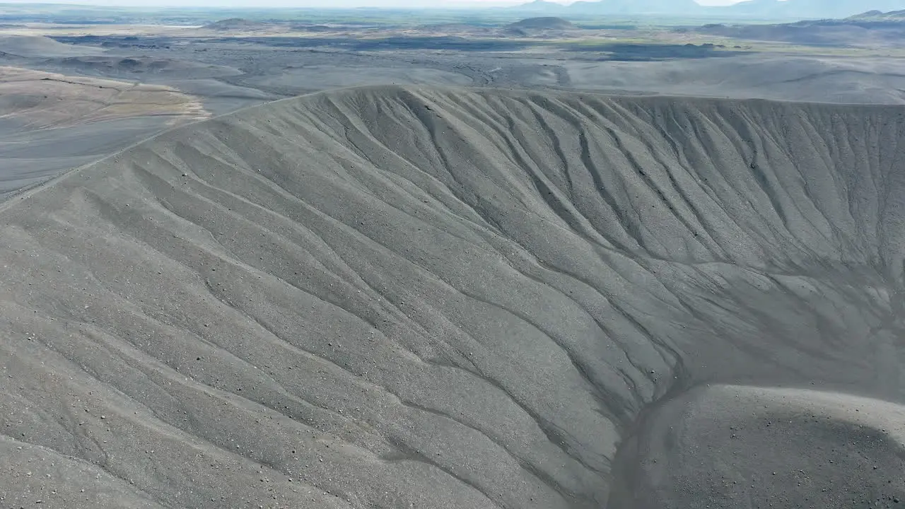 Volcano crater with black sand and scenic landscape in the background aerial