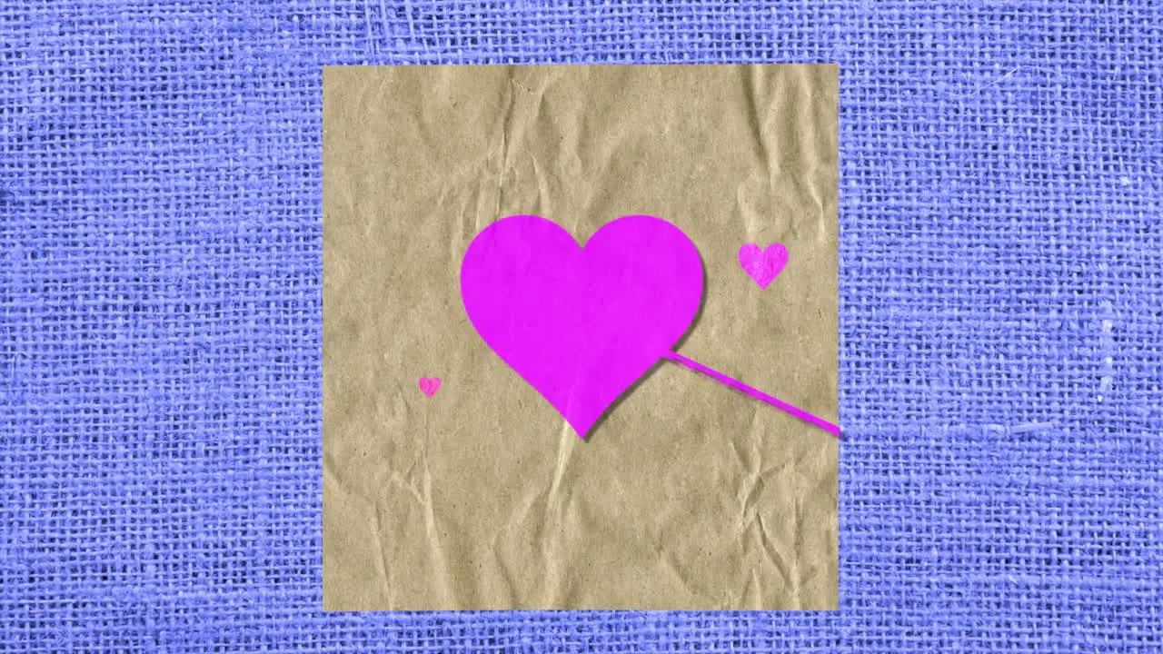 Pink hearts with arrow on paper and blue textile