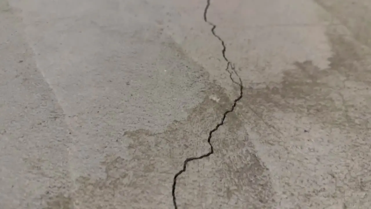 Close up of one long crack in concrete foundation in basement from settling home