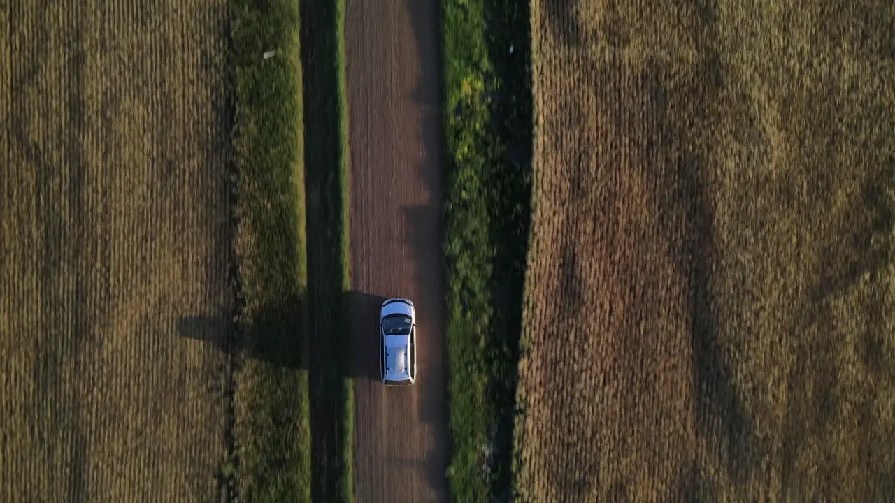 Aerial vertical view in 4k of parked minivan on a dusty dirt road in Canada's countryside