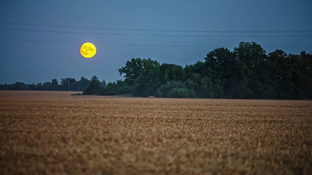 Timelapse of the moon rising over a field in the middle of the night