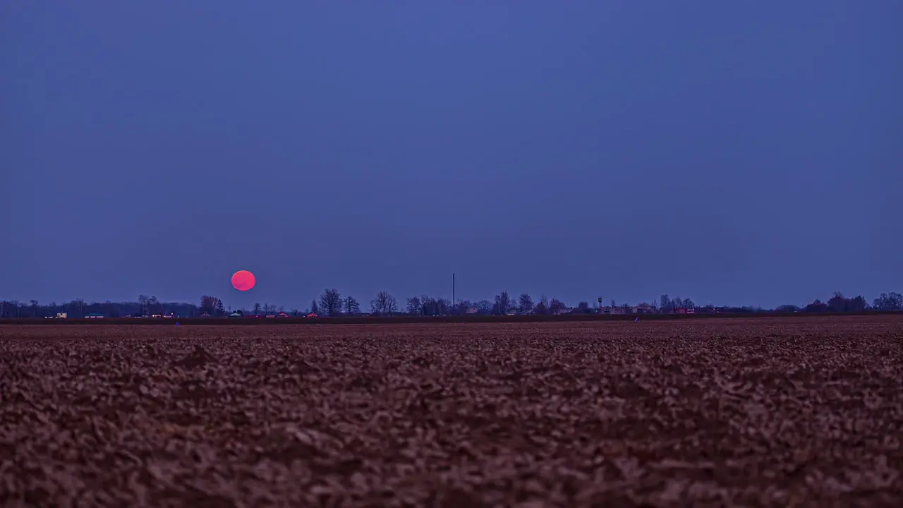 Timelapse of the moon is a bright crimson color as it ascends into the sky