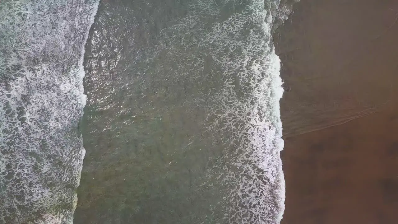 Overhead view of black sand beach and waves Karekare Beach New Zealand