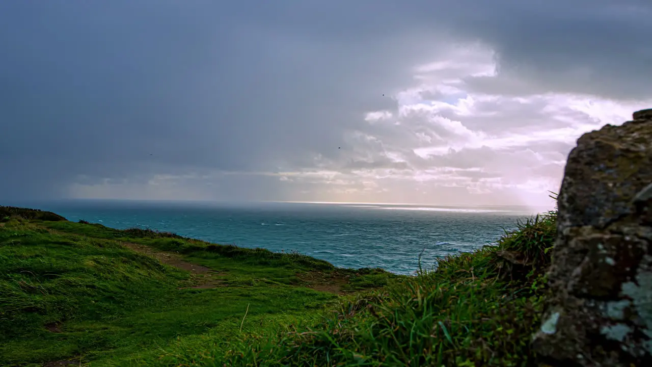 Time lapse of dark clouds flying over the ocean in green coastal area