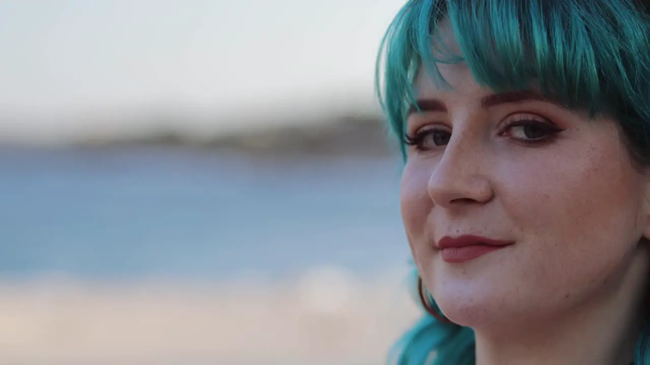 Close-up of blue hair Gen Z woman looking alluringly at camera copy space