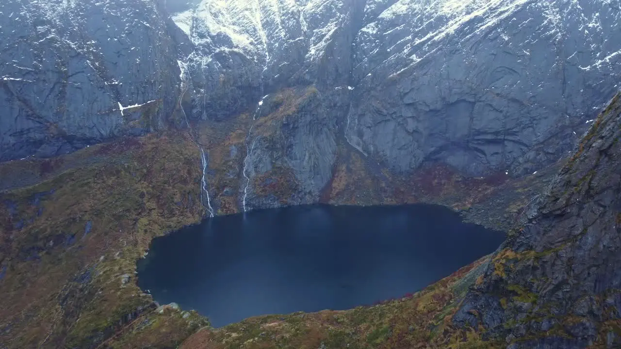 Crater lake surrounded by massive rocky mountains in Norway