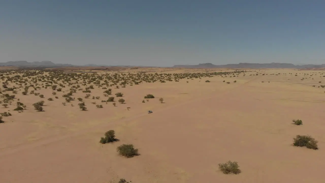 Car driving alone in the distance in desert