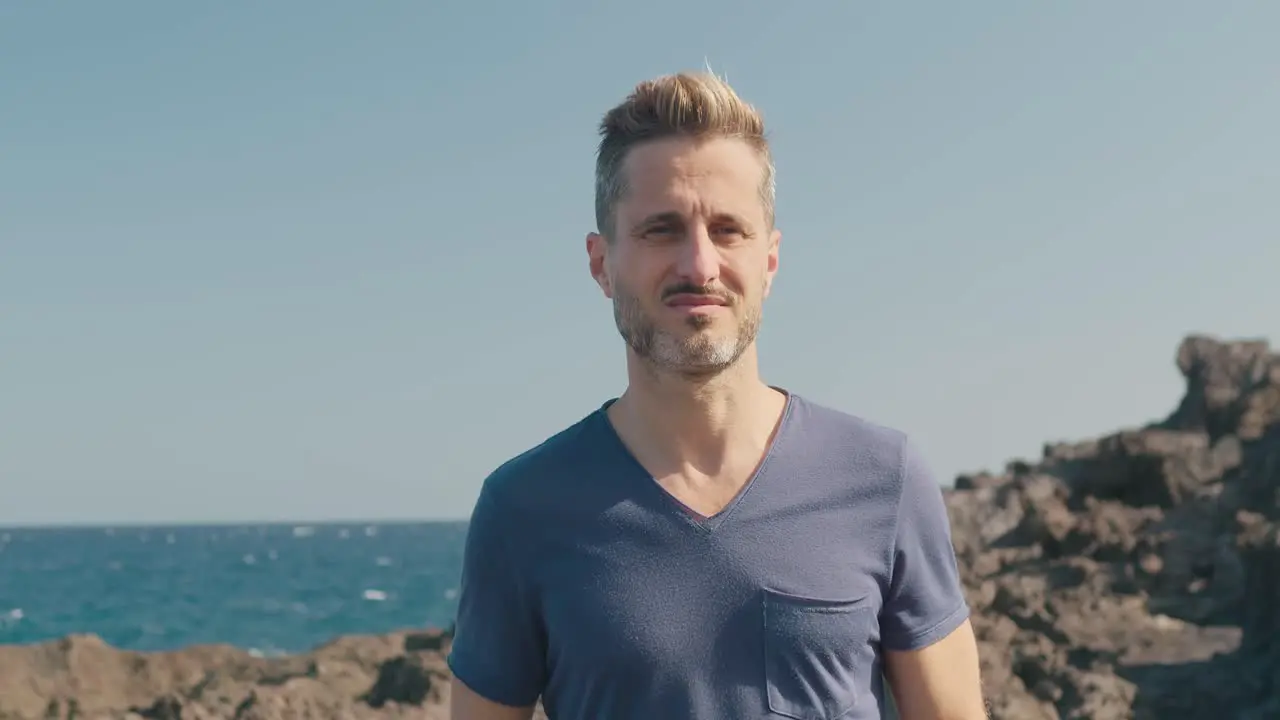 Male tourist walking on volcanic seashore