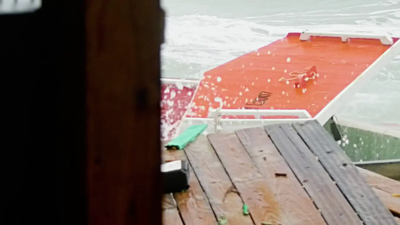 Slowmo close up of local wooden fishing boat being smashed into pieces during sudden storm with rough waves Caribbean