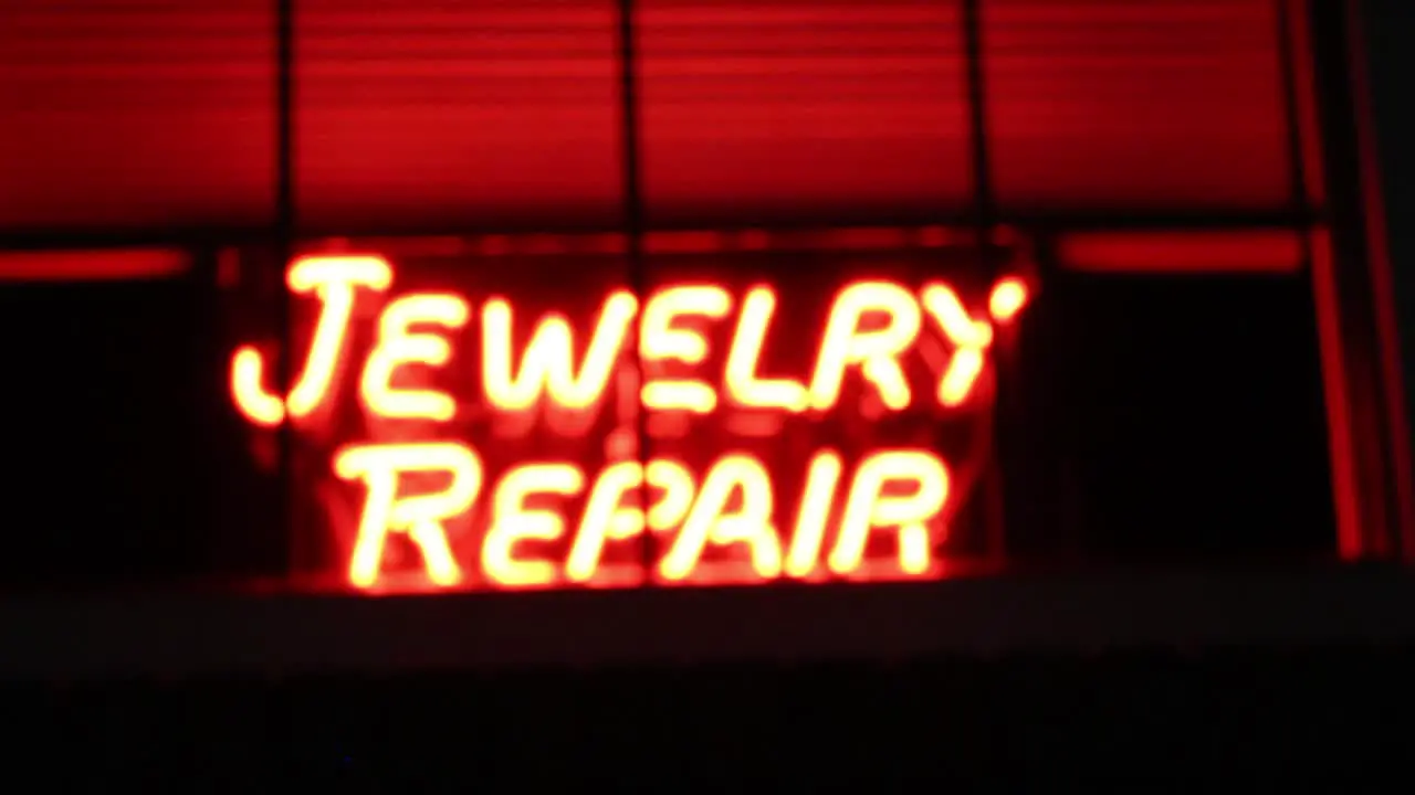 neon jewelry repair sign in-out of focus