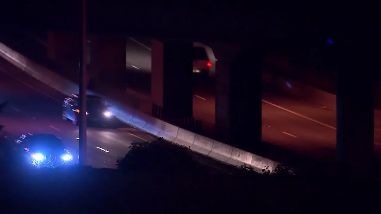 CARS DRIVING ON FREEWAY UNDERPASS AT NIGHT