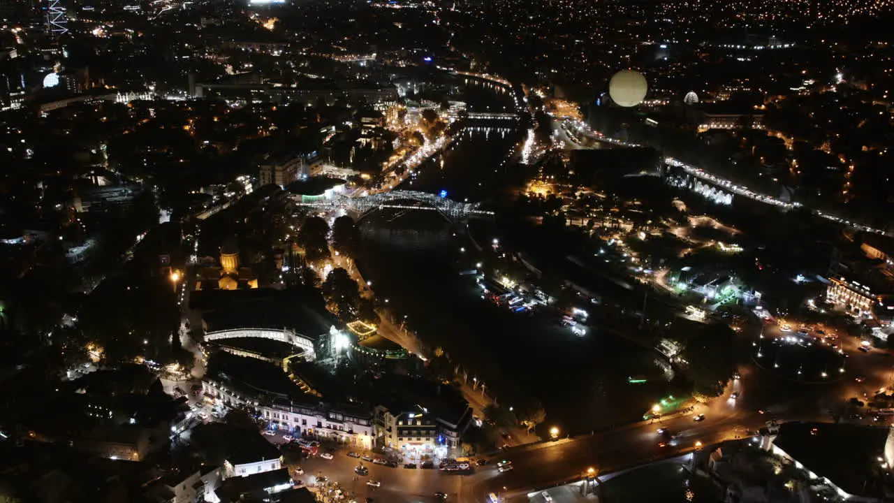 Aerial timelapse of downtown Tbilisi Georgia at night with traffic and hot air balloon and lights