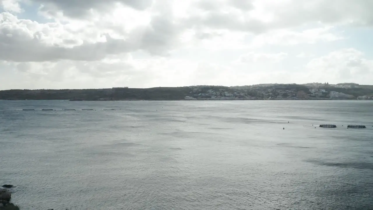 AERIAL Gloomy and Cloudy Day in Mellieha Bay with Fish Farm Cages Placed in Water