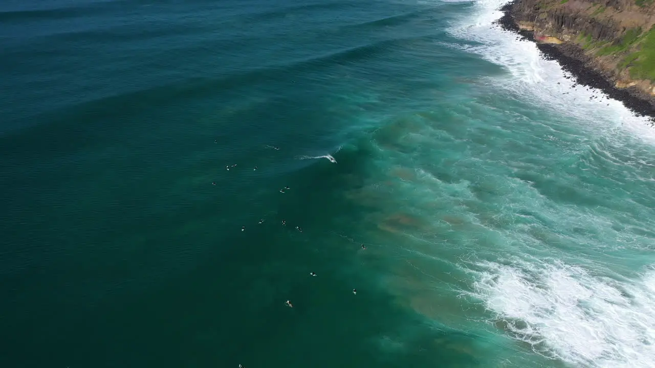 4k Aerial shot of people surfing by Lennox Head Australia