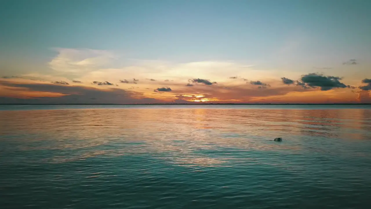 1 Million forwards slowly rise up drone shot at sunset from a dream beach to the sun