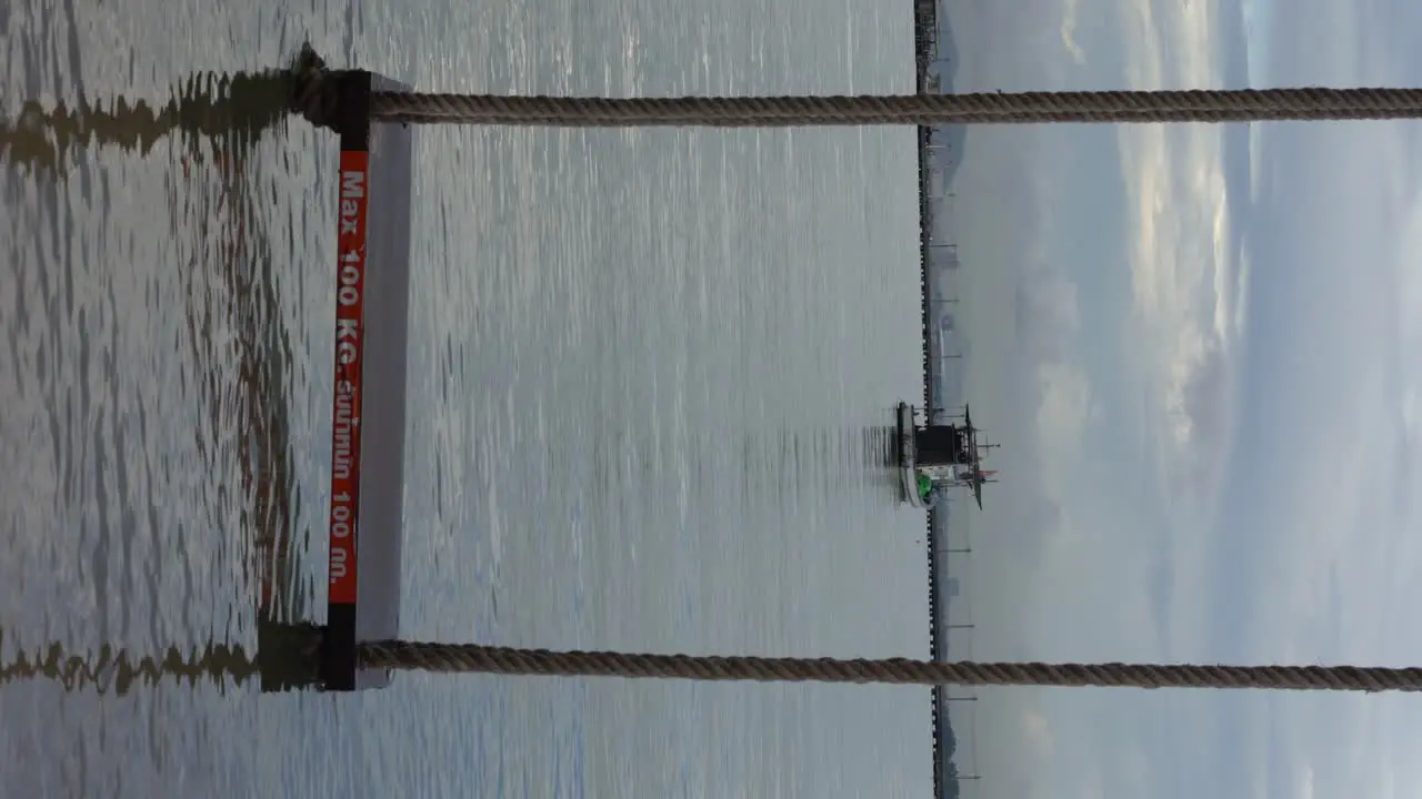 Vertical video Boat and sea view during high tide with a beach seesaw on the water