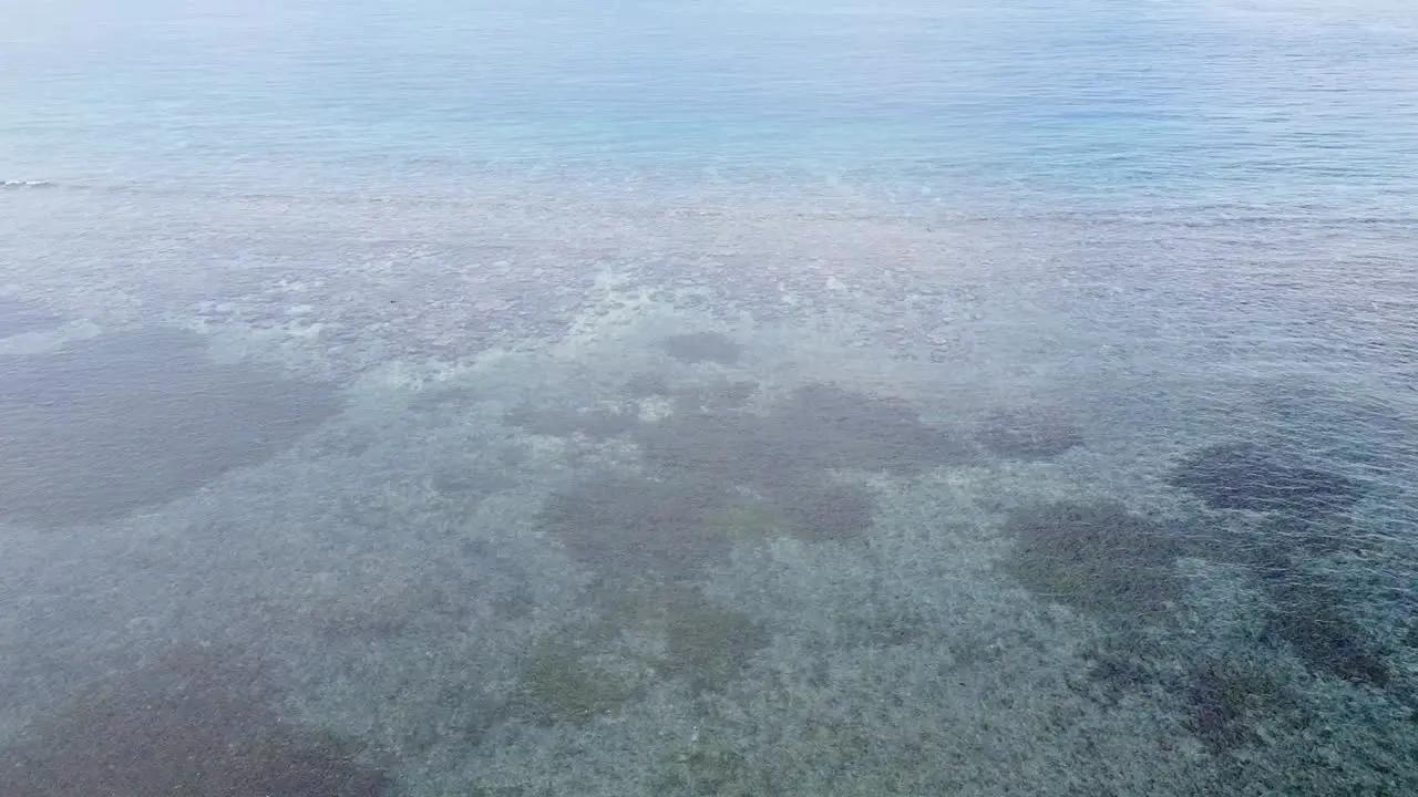 Aerial drone flight over ocean with coral reefs