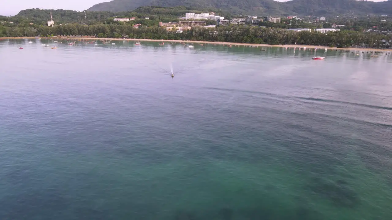 Drone aerial over Thailand during sunrise with boat driving on the ocean