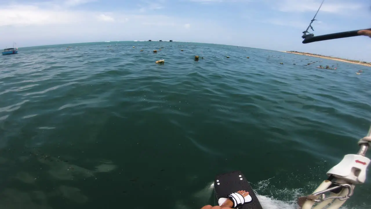 Spectacular pov shot of male kite surfer surfing over fishing nets in Pacific Ocean during vacation in Asia