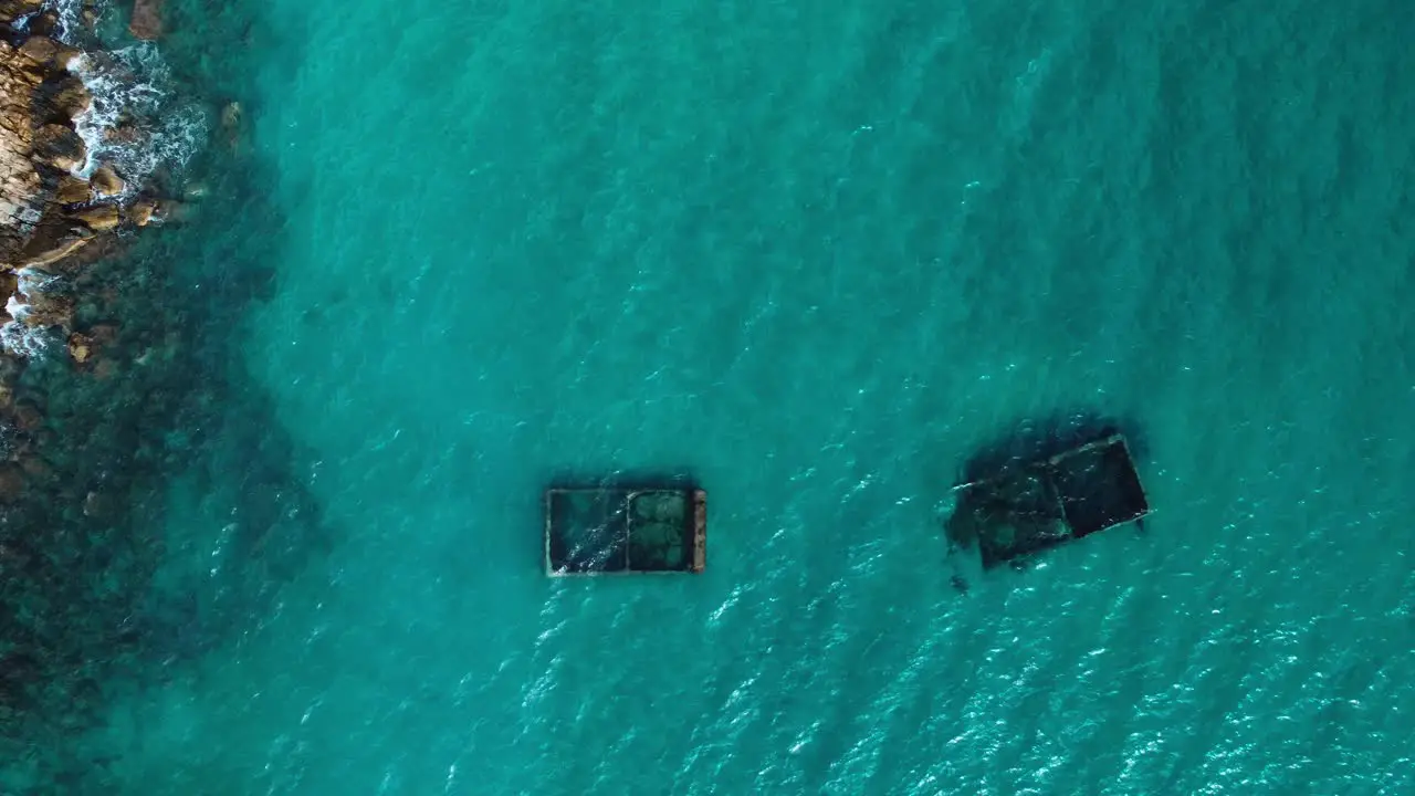 Top down aerial view of paradisiac crystal clear water with underwater structure