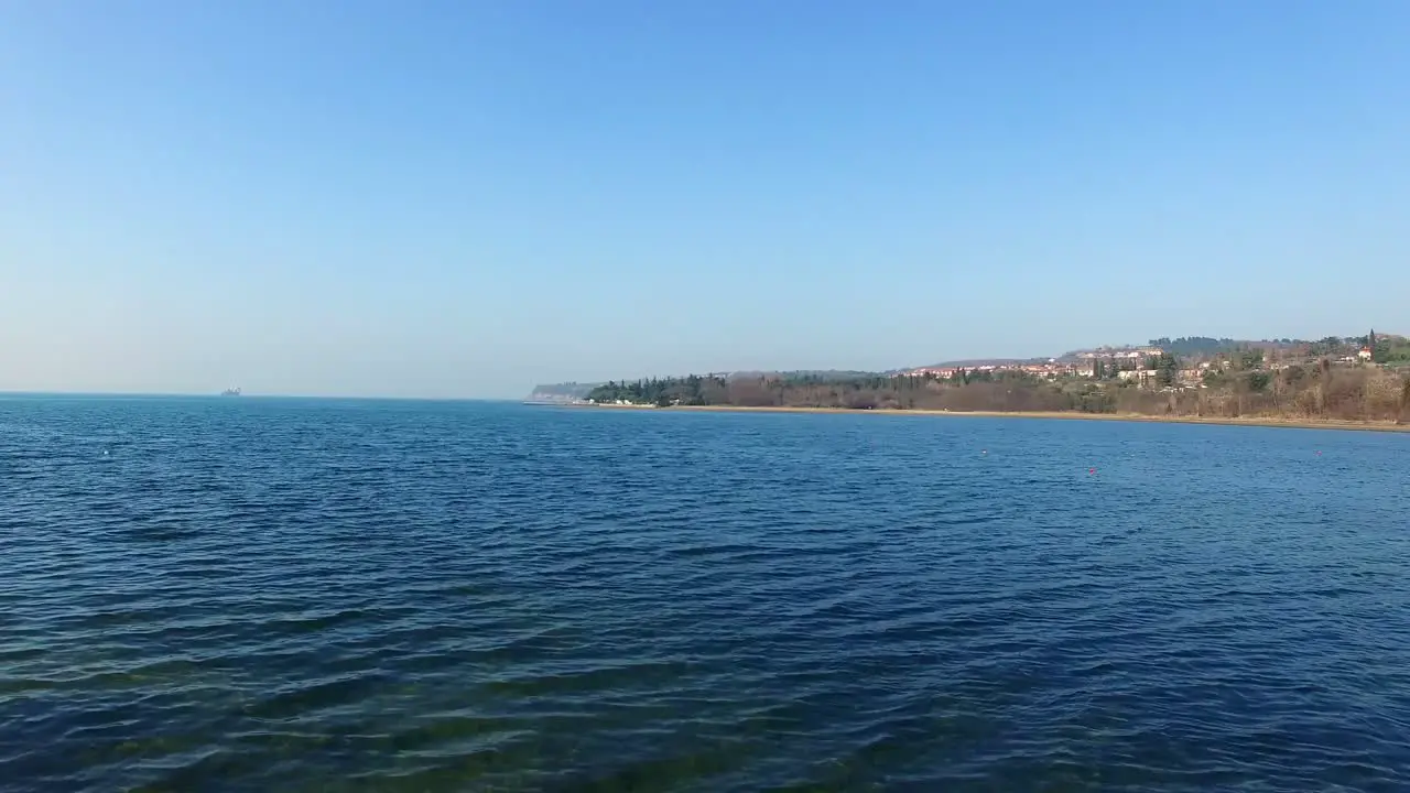 Flying Over Water with Boats and Camera Slowly Pans Left