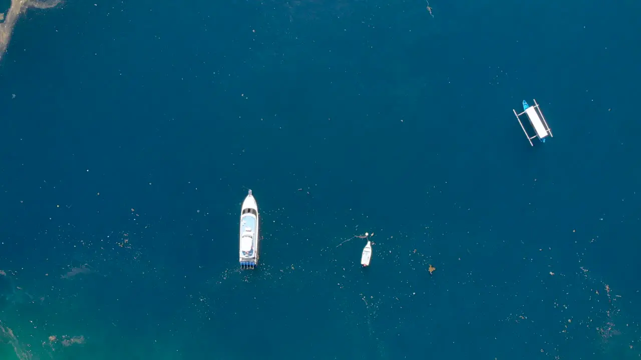 Aerial reveal shot of garbage in the ocean off the coast of Amed Bali Indonesia