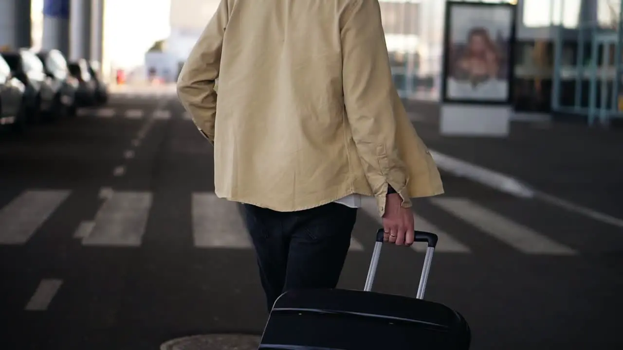 Close Up Cropped Shot Of Married Man With The Black Baggage Walking To The Outside Airport Terminal By Road